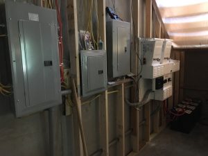 Breaker boxes and battery inverter wall by Keowee Home Solar